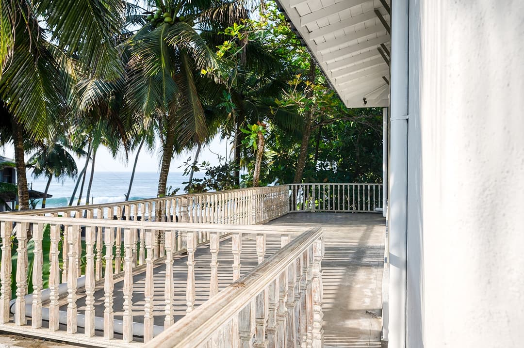 Beachfront villa master bedroom with four-poster bed and blue canopy Unawatuna