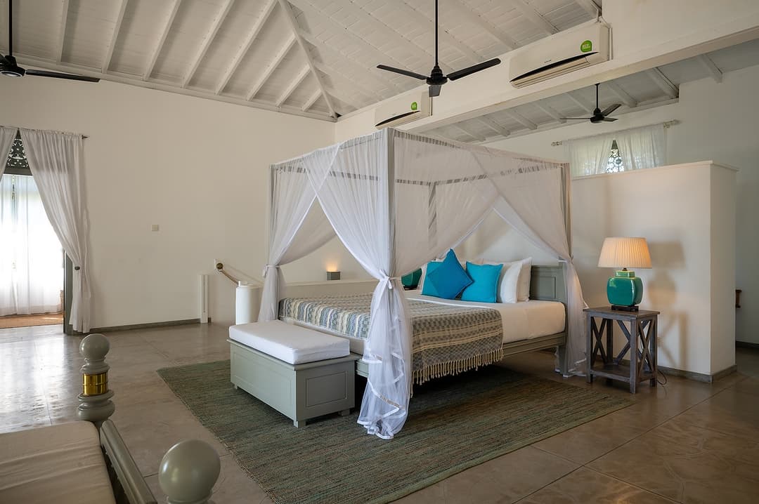 Beachfront villa master bedroom with two four-poster beds wide angle Unawatuna