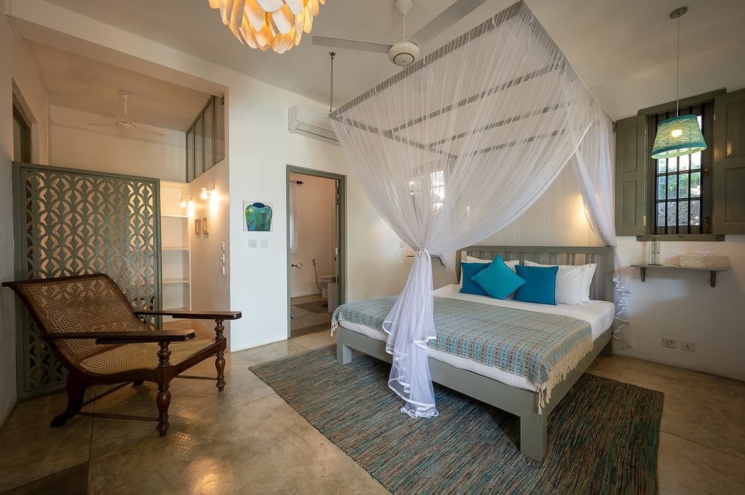 Beachfront villa master suite with four-poster bed and ceiling fan Unawatuna