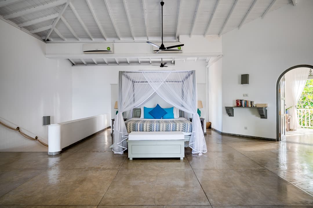 Wide angle view of beachfront villa master suite with four-poster Unawatuna