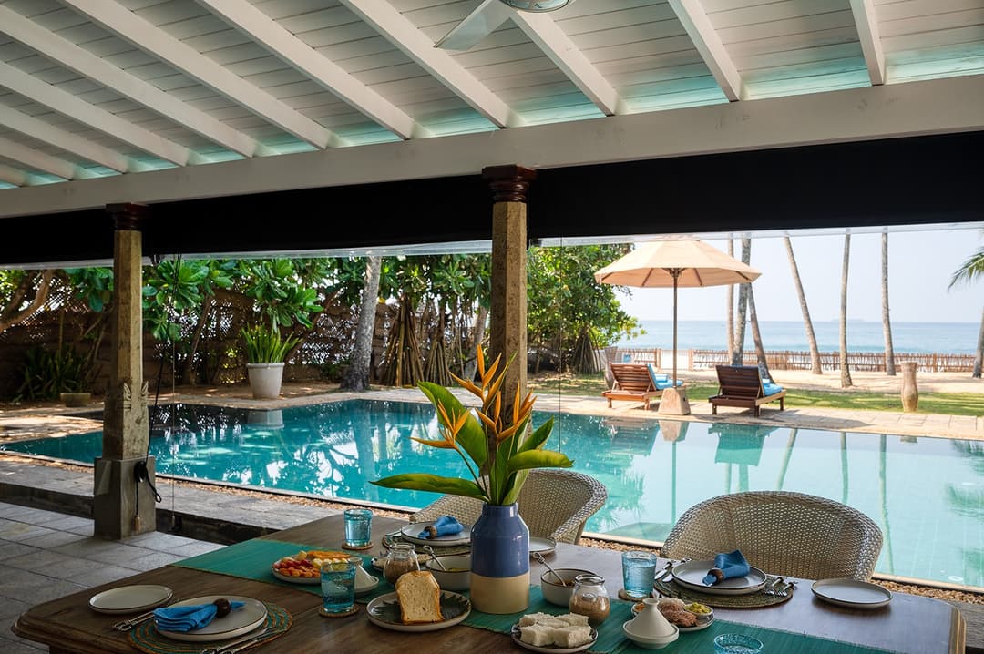 Beachfront villa pool with coconut palms and garden leading to beach Unawatuna