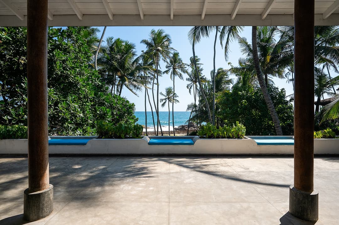 Villa Bleu Unawatuna pool terrace with tall coconut palms and Indian Ocean view