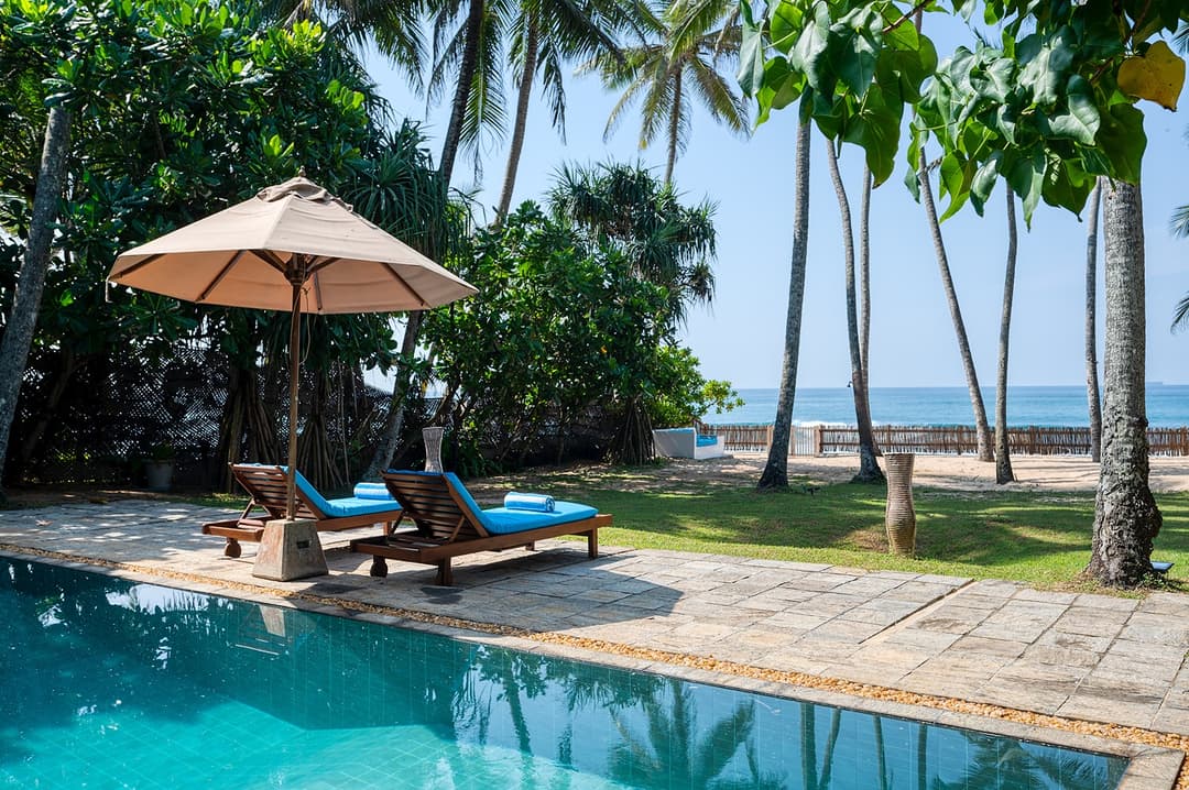 Villa Bleu Unawatuna pool with thatched umbrella, sun lounger and beach access
