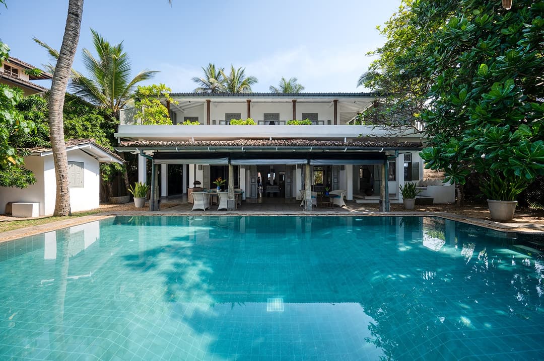 Villa Bleu Unawatuna pool and villa facade with coconut palms in daytime