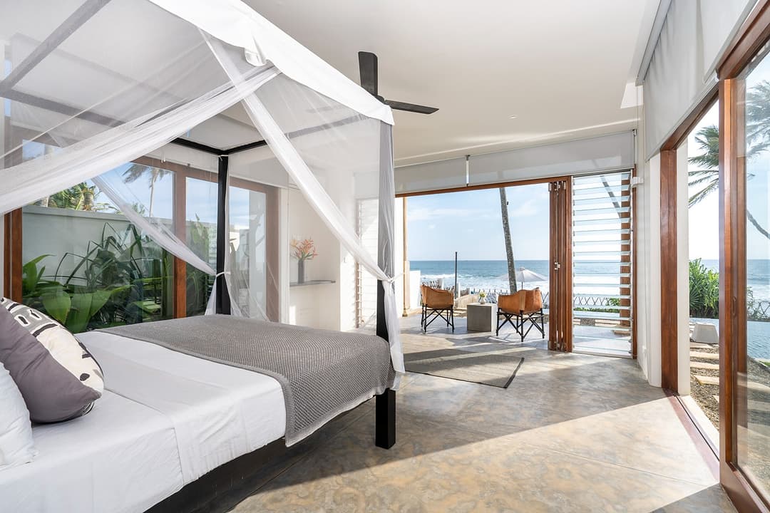 Talpe beachfront villa bedroom with canopy bed and timber window frame