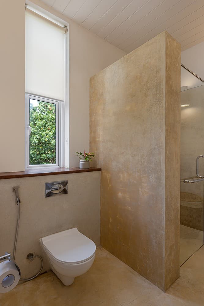 Ahangama beachfront villa ensuite with dark concrete shower and stone basin