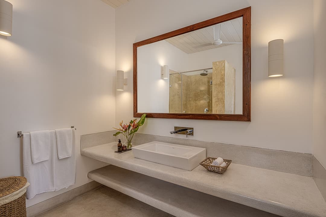 Ahangama beachfront villa bathroom with stone basin and warm-lit mirror