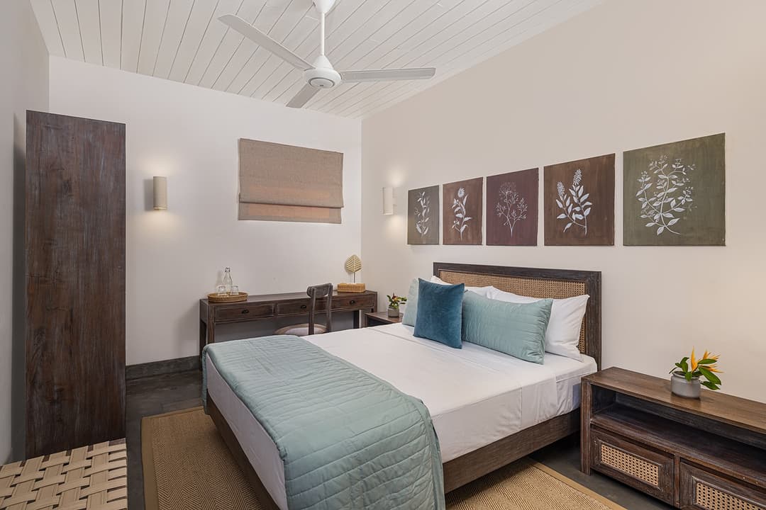 Ahangama beachfront villa bedroom with dark timber headboard and teal cushions