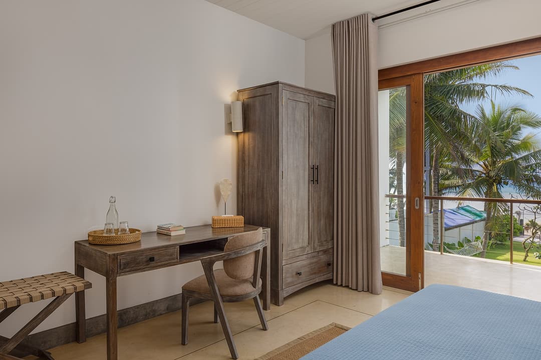 Ahangama beachfront villa bedroom with ocean view, desk and palm trees