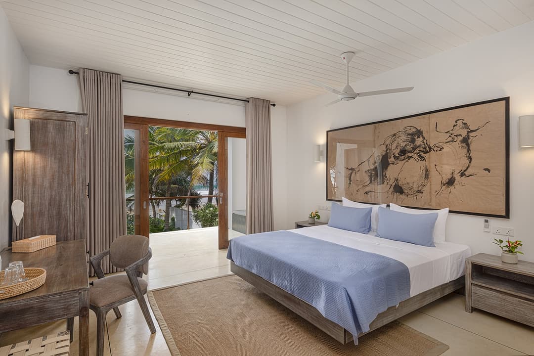 Ahangama beachfront villa bedroom with teal blue artwork and king bed
