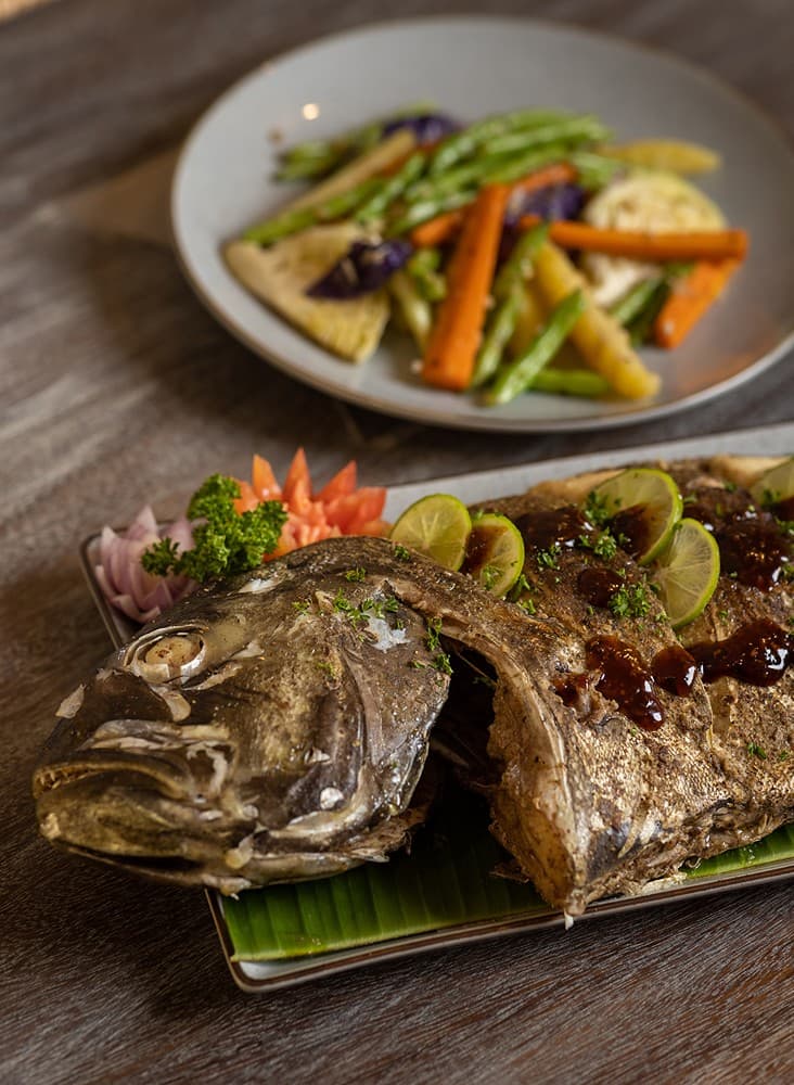 Ahangama beachfront villa chef whole grilled fish on banana leaf with vegetables