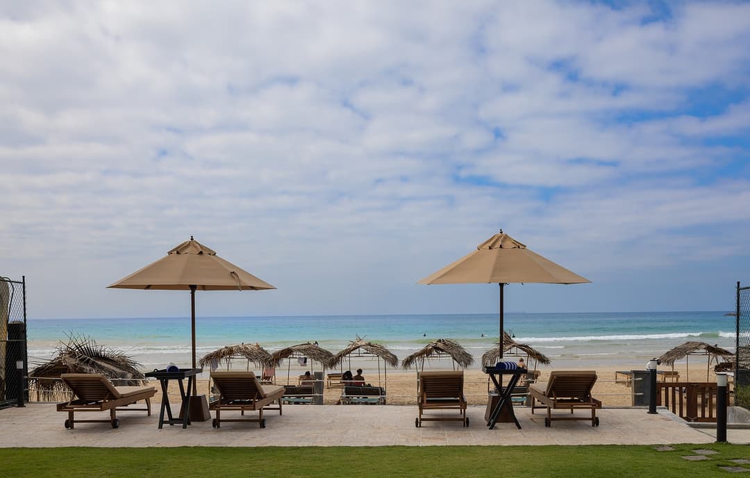 Ahangama beachfront villa pool with sun loungers and umbrellas leading to beach