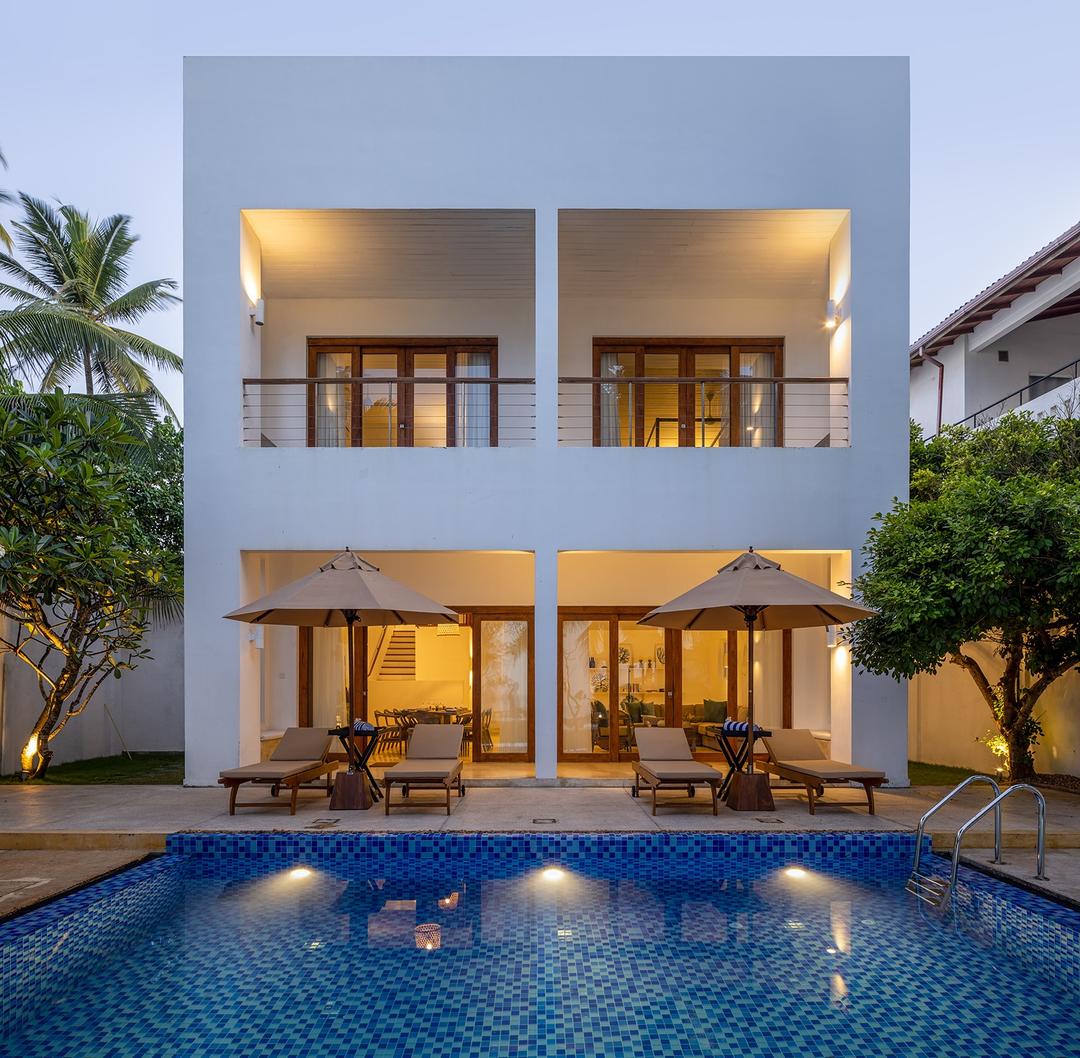 Verde Ahangama pool and exterior illuminated at evening with palm trees