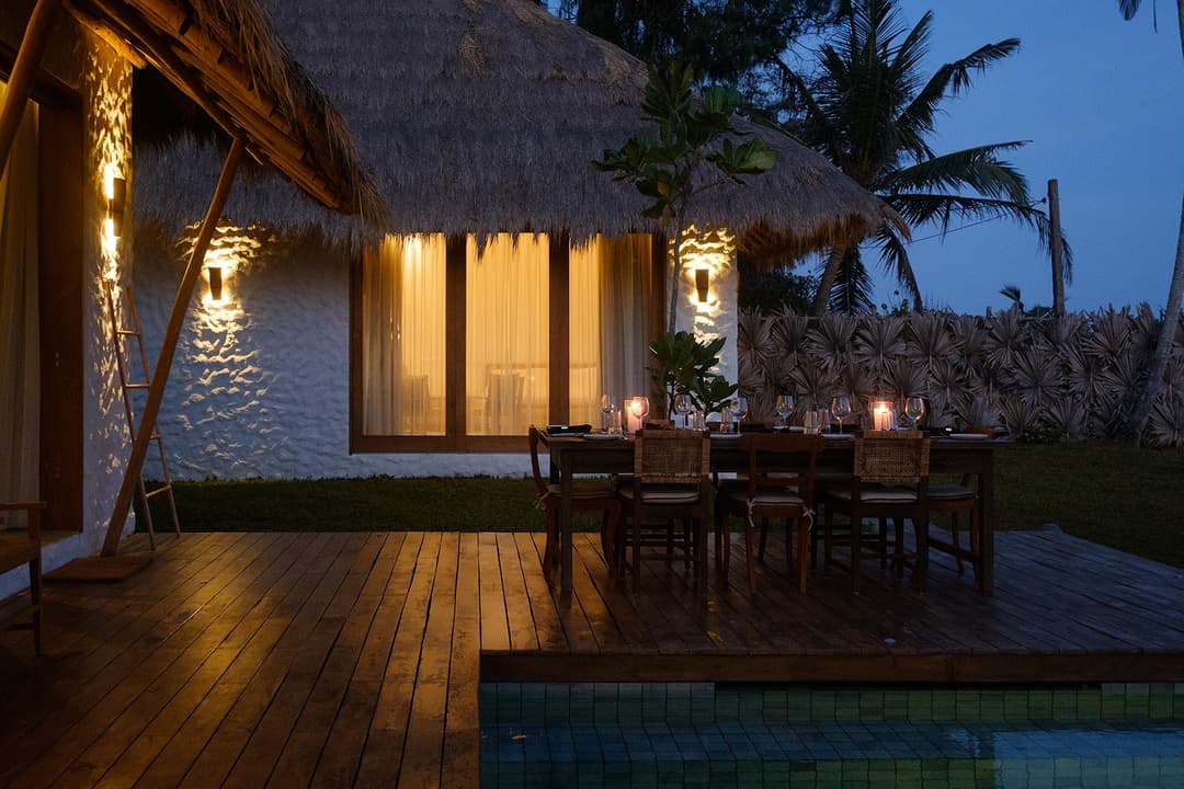 Boho House Mirissa exterior and pool illuminated at evening with palm trees