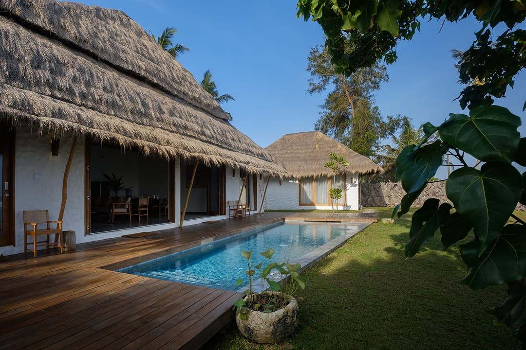 Boho House Mirissa pool with thatched villa facade and ocean view