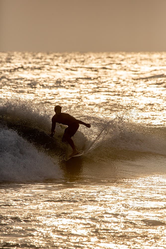Thalaramba beach golden sunset wave surfer