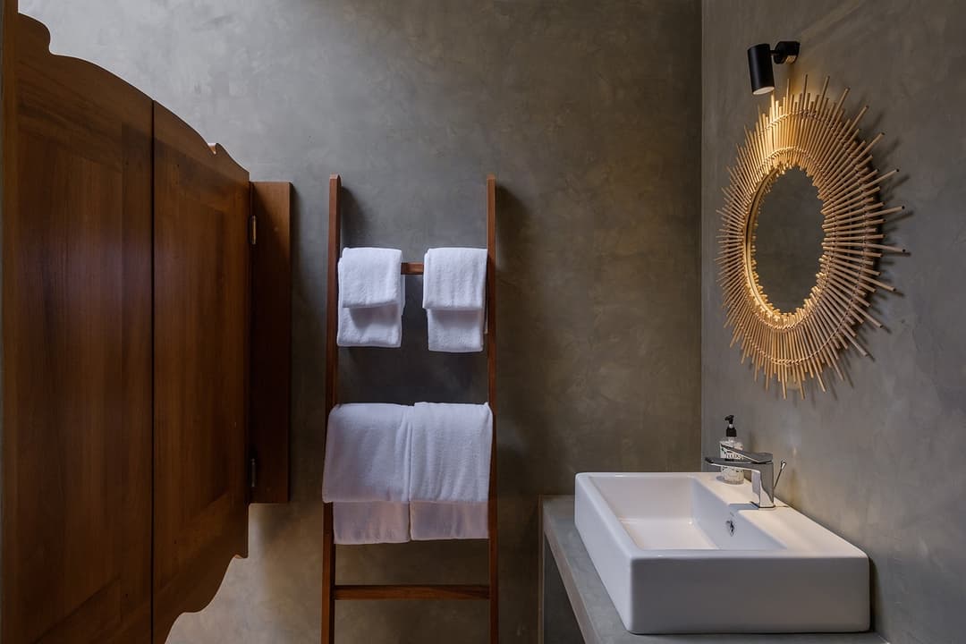 Mirissa villa ensuite bathroom with round mirror and timber cabinet