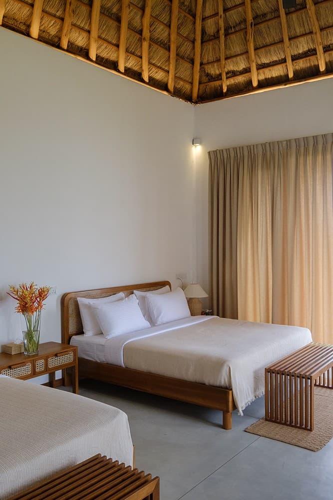 Mirissa villa bedroom with king bed and wide thatched timber ceiling