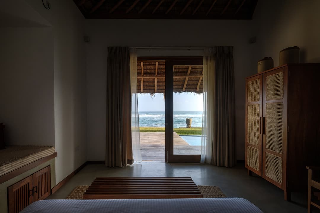 Mirissa villa bedroom timber door framing Indian Ocean view