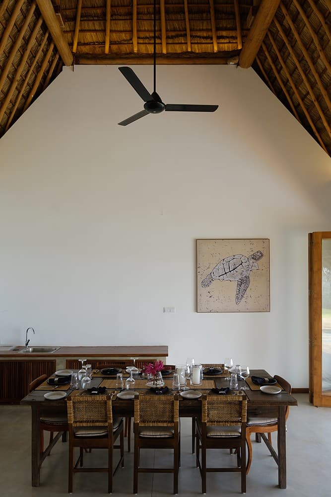 Mirissa villa dining room with thatched ceiling and dark timber table set