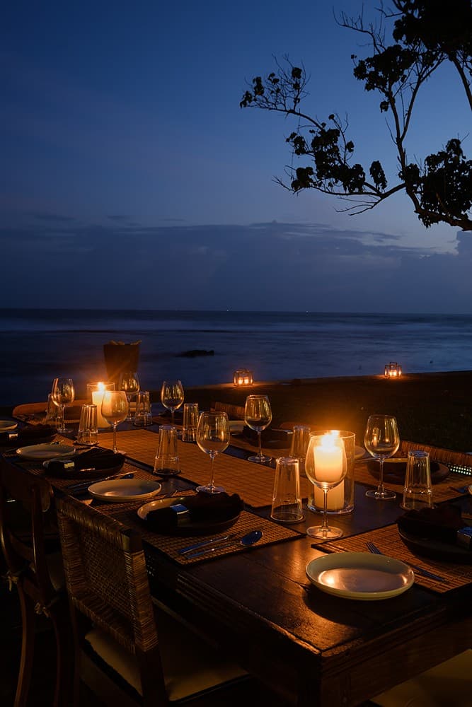 Mirissa villa wide outdoor dining table with candles and ocean evening