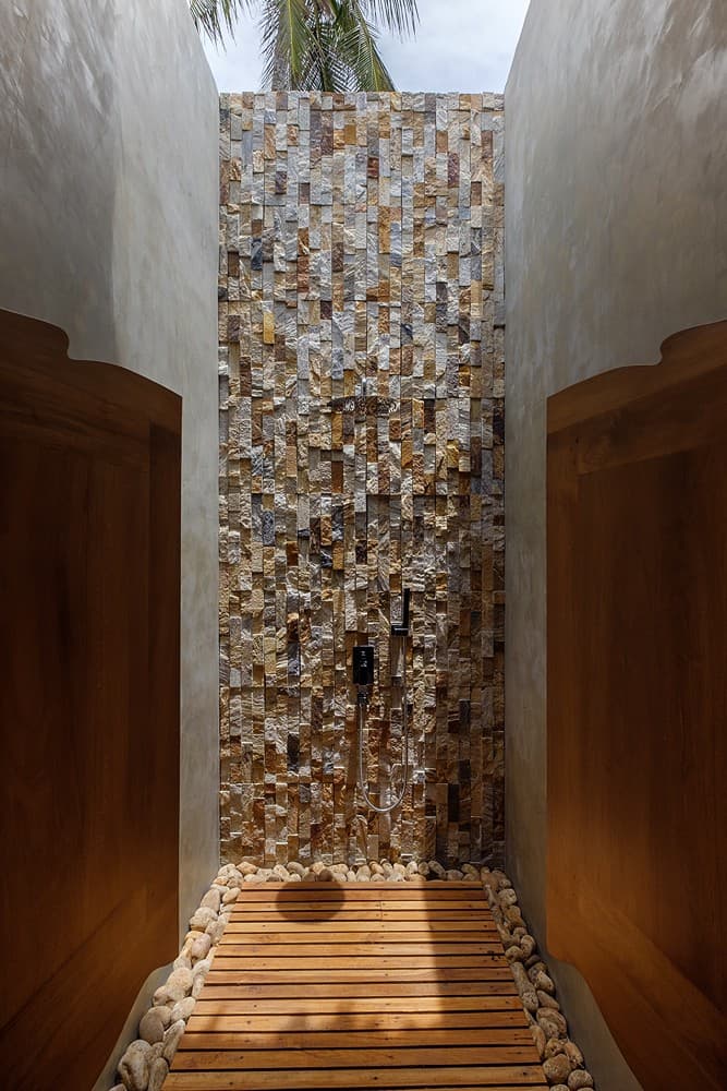 Mirissa villa outdoor shower with pebble stone wall and timber floor