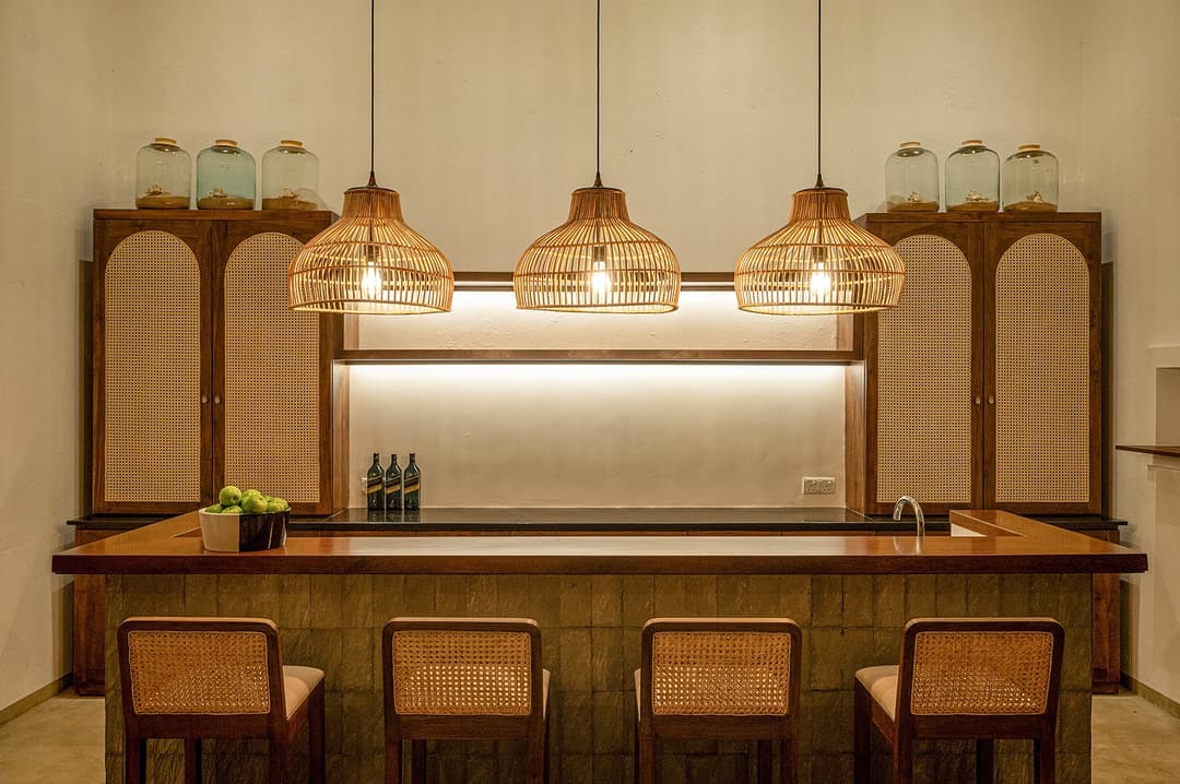 Mirissa luxury villa bar at night illuminated with rattan pendants and greenery
