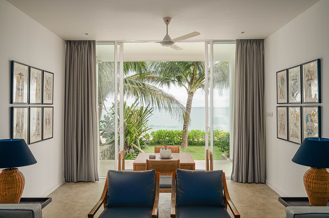 Mirissa luxury villa bedroom with blue curtains, timber floor and garden view