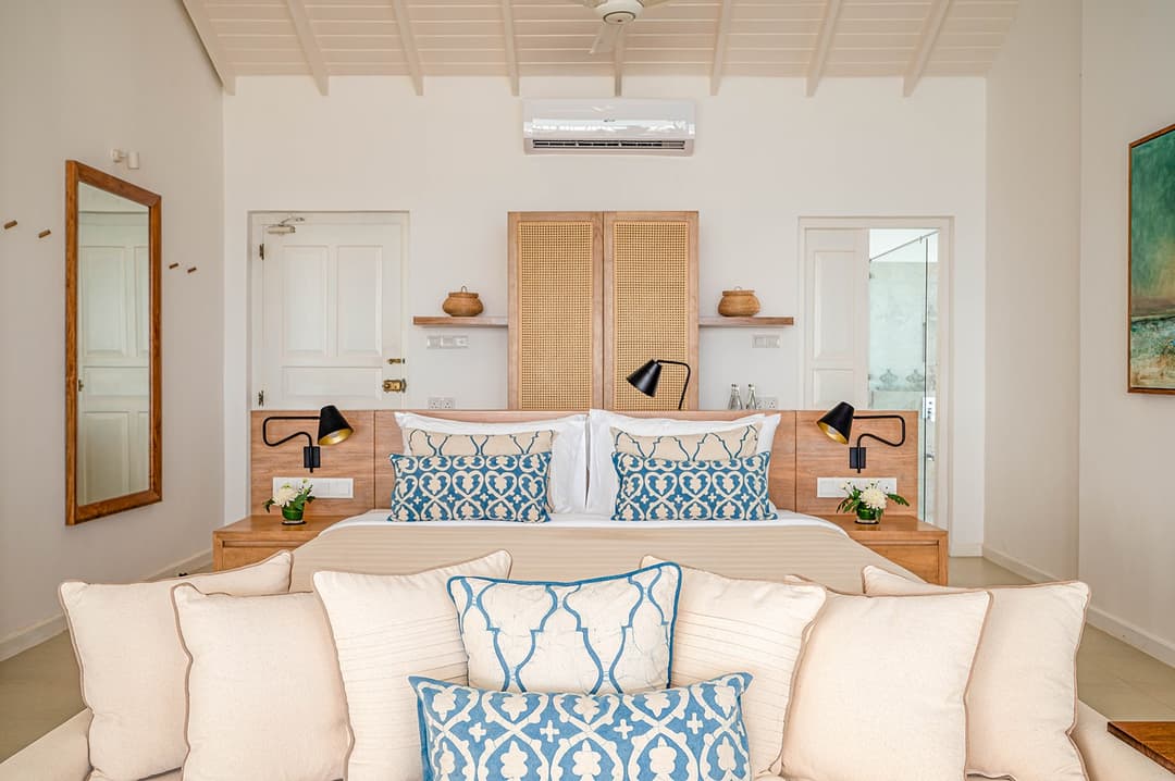 Mirissa luxury villa bedroom with blue accent cushions and timber shelving