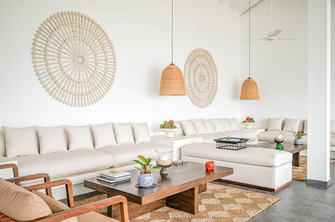 Wide view Mirissa luxury villa living room with rattan wall art and white sofas