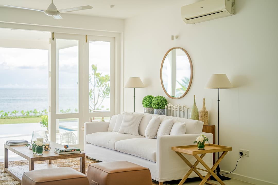 Mirissa luxury villa living room with white sofa, round mirror and lamp