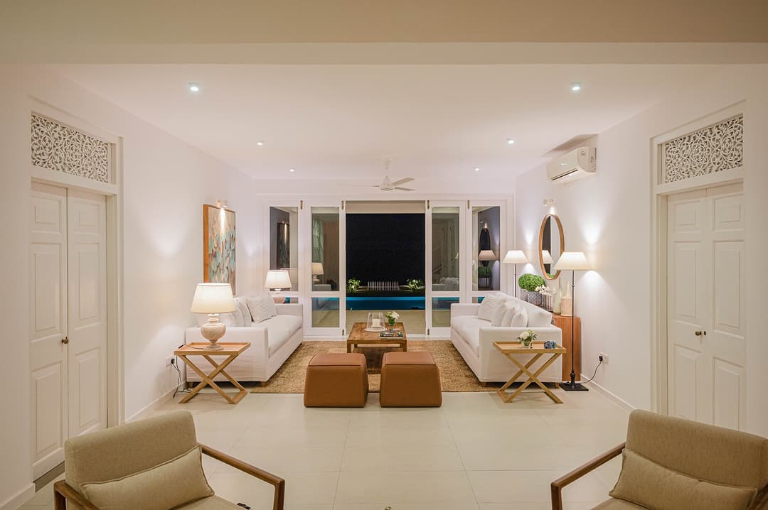 Mirissa luxury villa living room with white sofas and TV unit lit at night