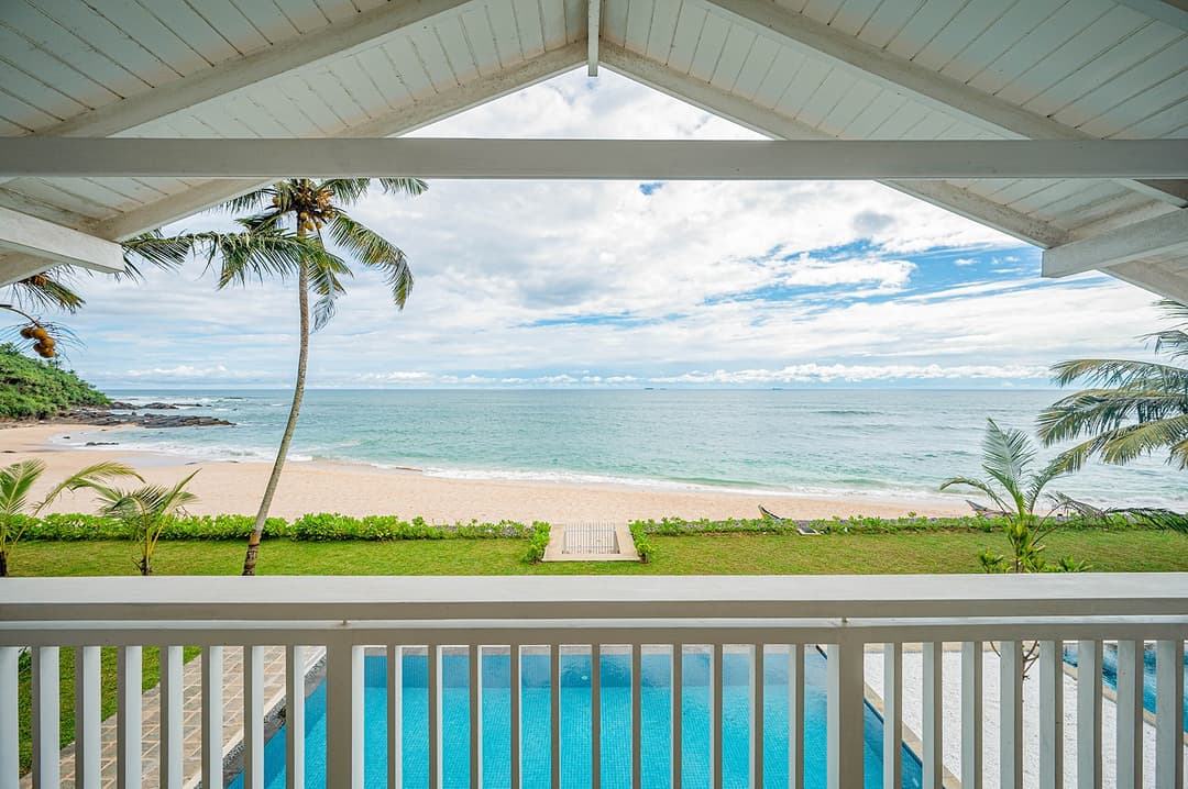 Mirissa luxury villa veranda with white balustrade and ocean view palm