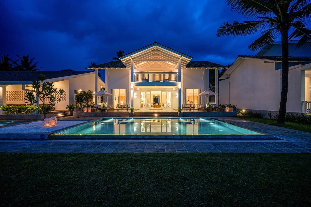 Sol House Mirissa exterior at night with illuminated pool and palm trees