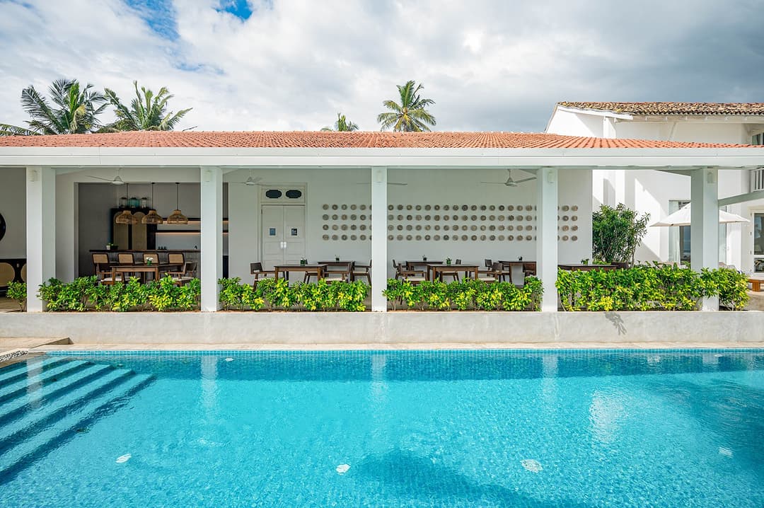 Sol House Mirissa white facade exterior with pool and tropical garden