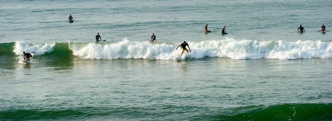 Wide view of surfers in line up on Matara beach waves Sri Lanka