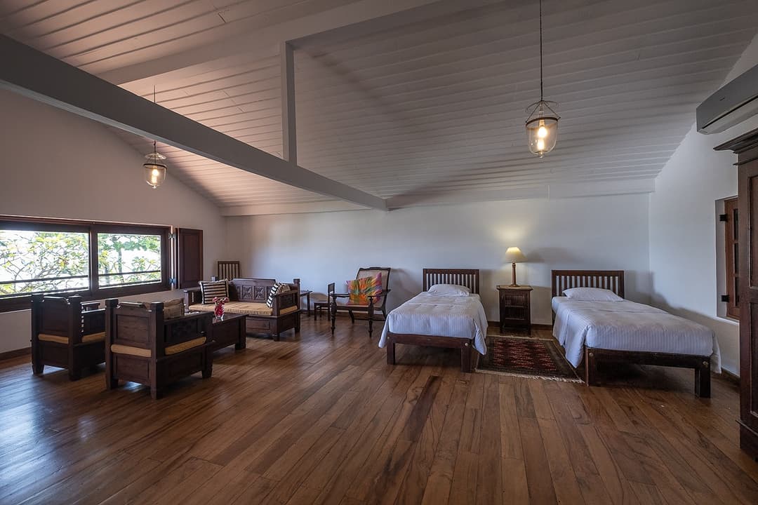 Matara villa bedroom with high ceiling, twin beds and timber floor