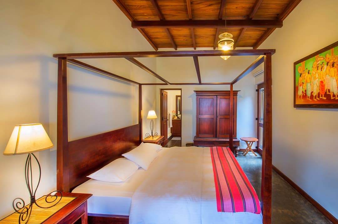 Matara villa courtyard room with four-poster bed and colourful artwork