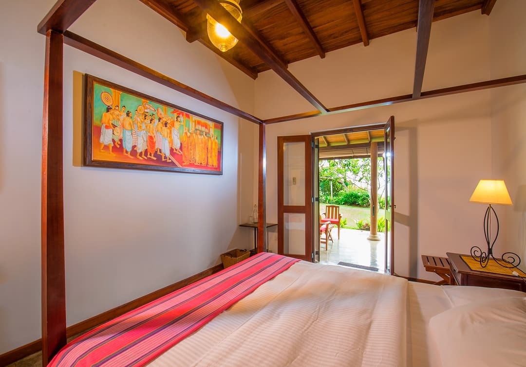 Matara villa courtyard room with four-poster bed and garden door