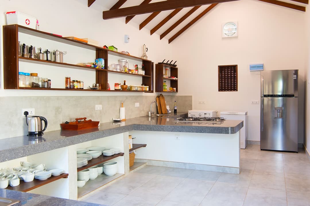 Matara villa open plan kitchen with white counter, shelving and fridge