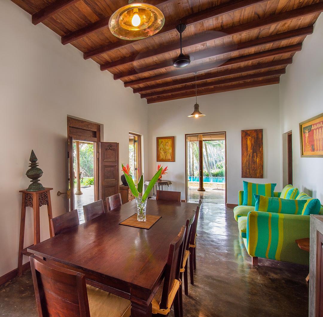 Matara villa living and dining area with antique table and green chairs