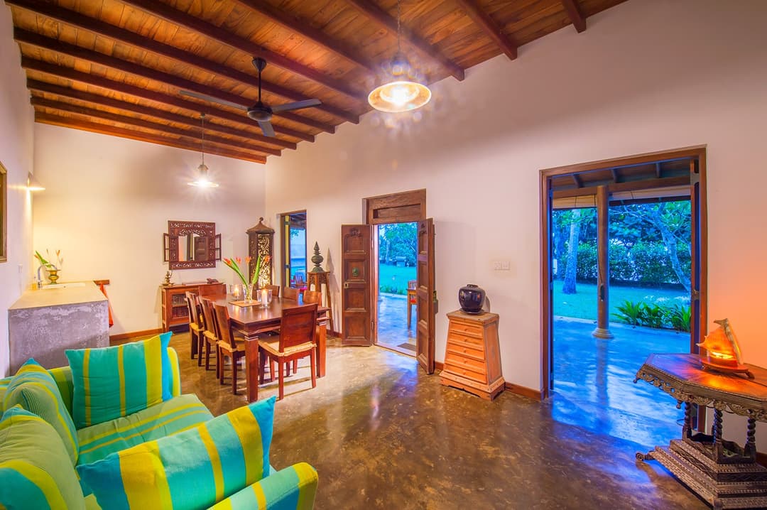 Matara villa living room with green seating and open ocean view wide