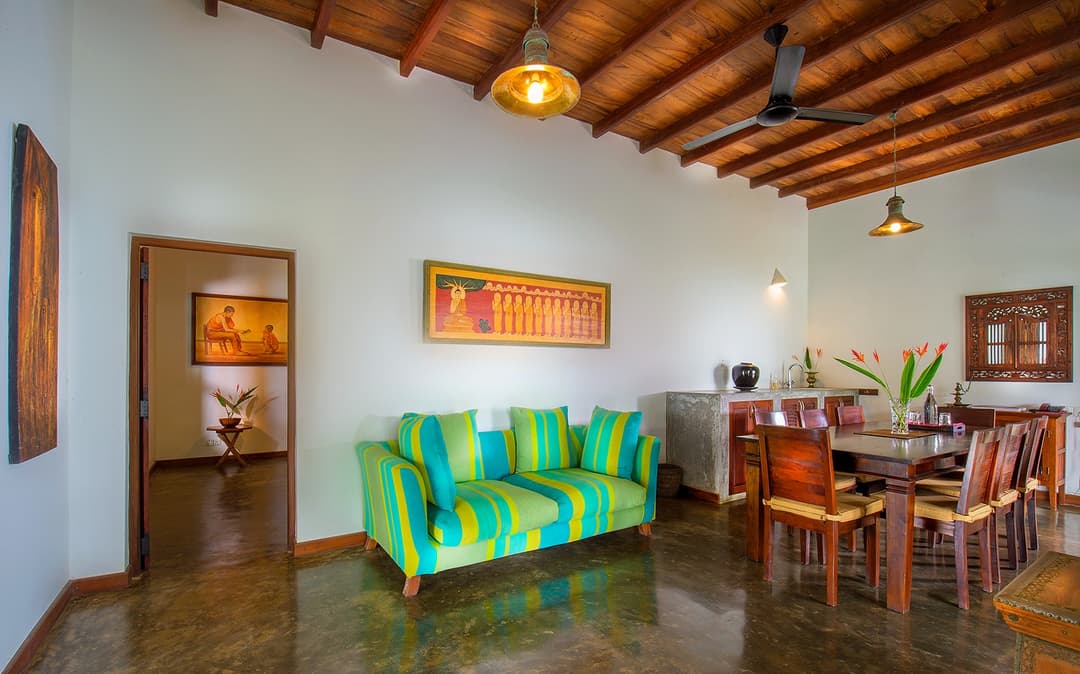 Matara villa living room with green sofas, dining table and high ceiling