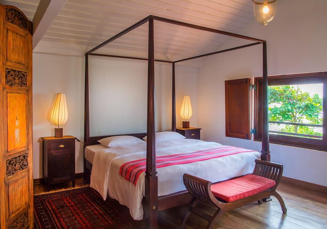 Matara villa loft bedroom with king four-poster bed and timber antiques