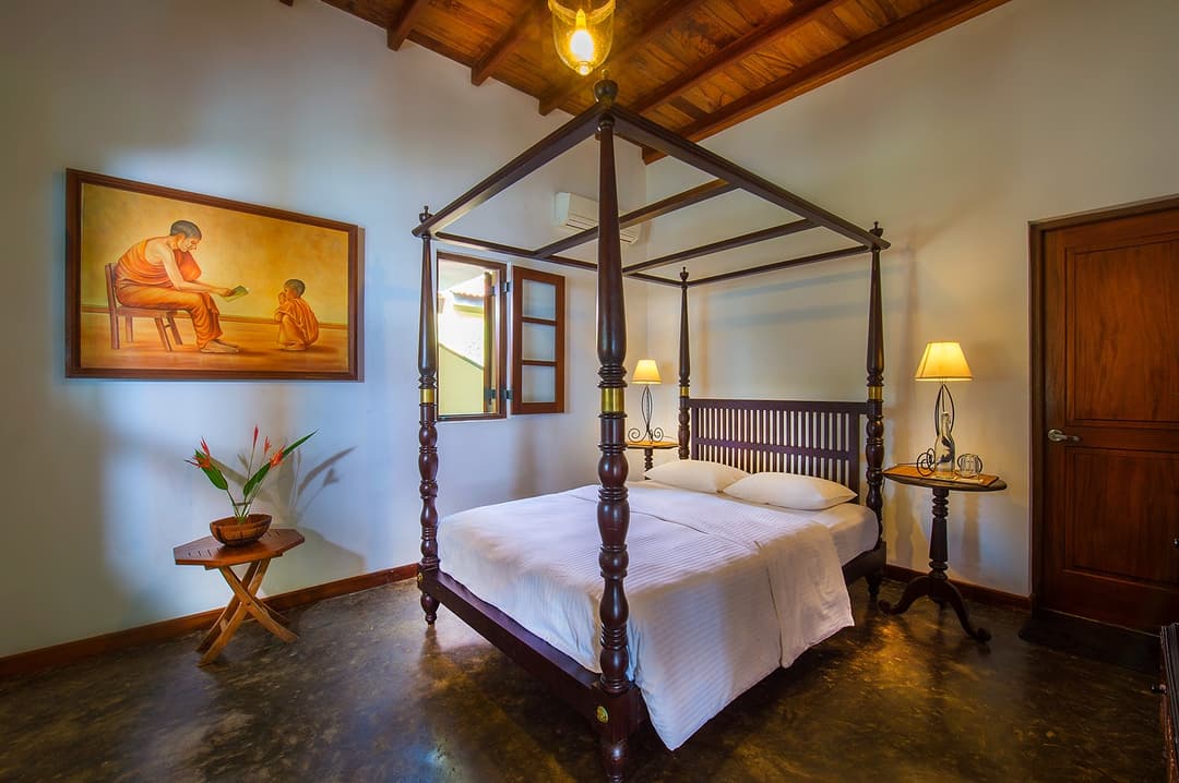 Matara villa poolside room full view of four-poster bed with artwork