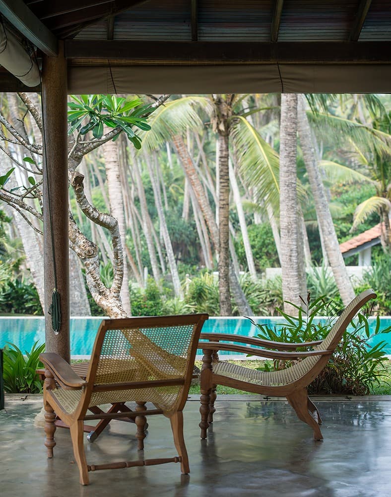 Matara villa veranda with planter chairs and coconut trees garden