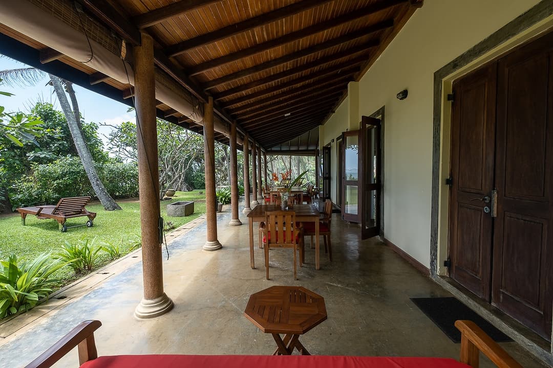 Matara villa L-shaped veranda with timber columns and garden ocean view