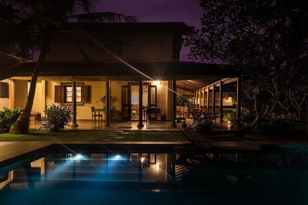 Villa Tres Matara exterior and pool illuminated with warm evening light