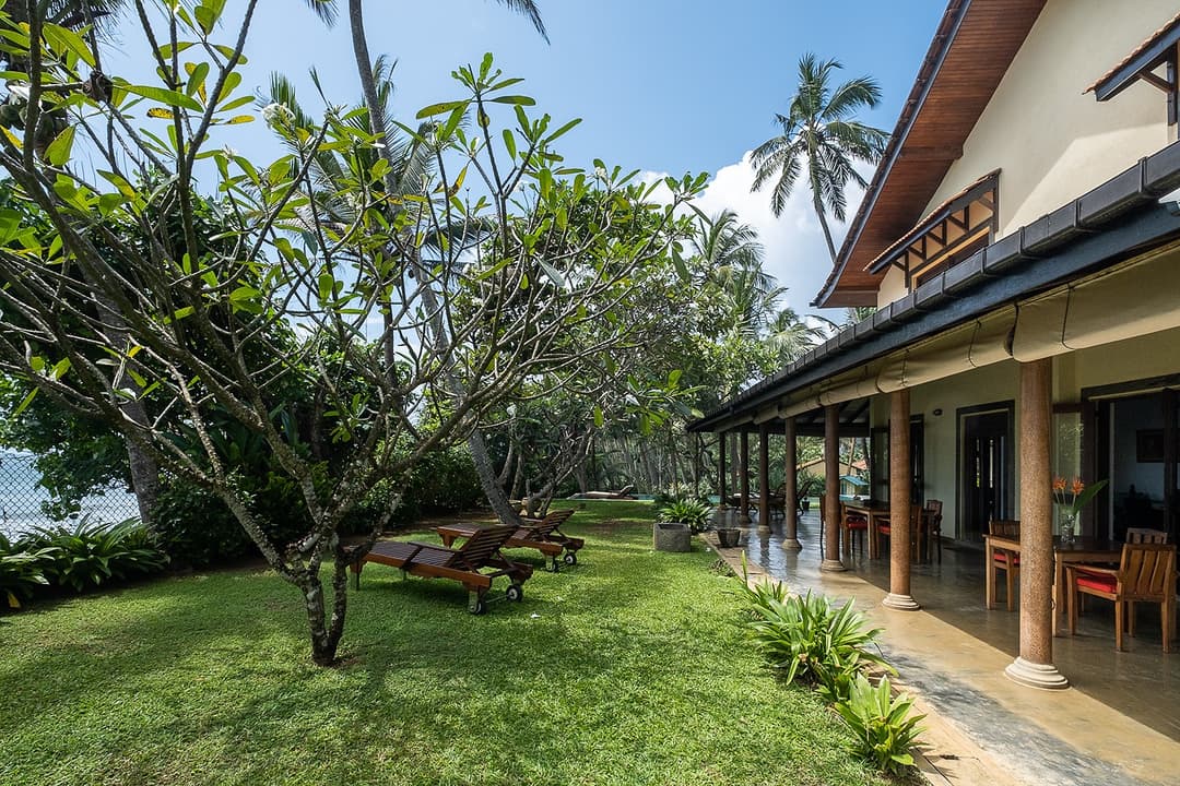 Villa Tres Matara exterior with tropical garden and veranda ocean view