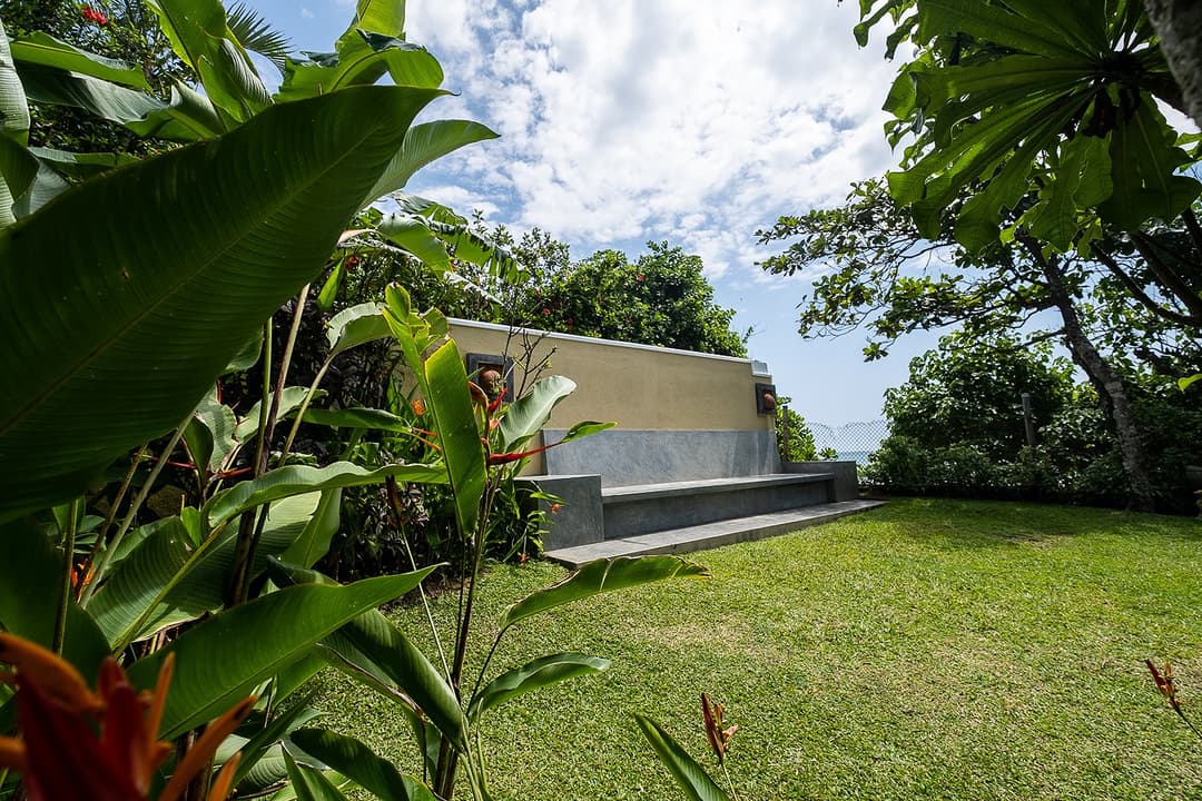 Villa Tres Matara exterior with lush tropical garden and coconut palms